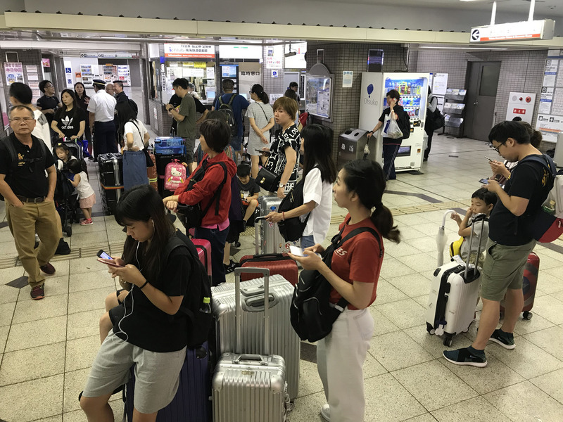 日本關西地區遭遇「歷史性」豪雨襲擊，部分電車鐵道停駛，大批旅客6日在大阪市天下茶屋站內滯留，等待發車。 圖/中央社
