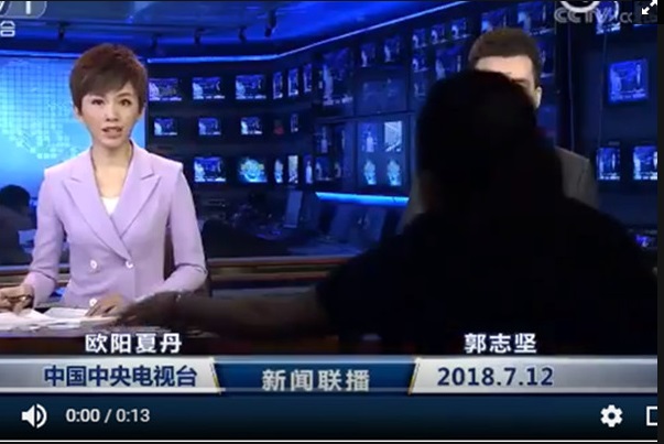 中國官媒央視12日全國聯播的《新聞聯播》新聞畫面中出現黑衣人。 圖/翻攝自網路