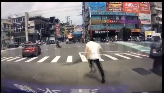 合庫行員面對持槍搶匪無所畏懼，持棍棒追打。 圖：影片截圖