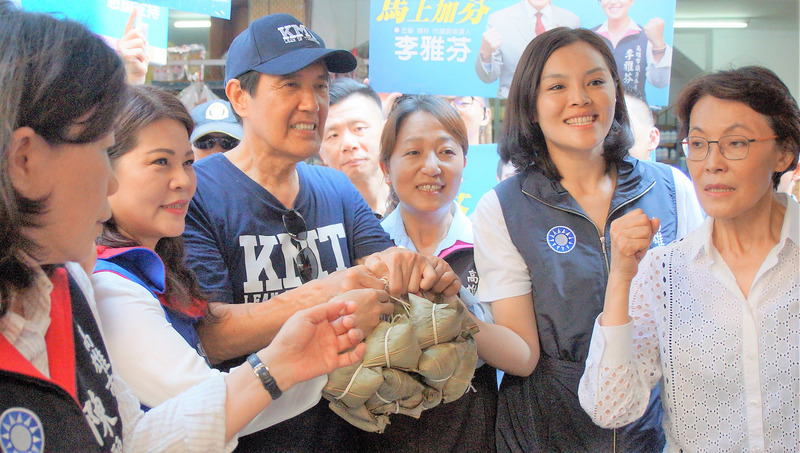 前總統馬英九（前左3）21日南下高雄輔選，首站來到左營果貿市場陪同多名國民黨市議員參選人掃街拜票，有攤商特別送上粽子為馬英九加油，場面熱烈。 圖：中央社