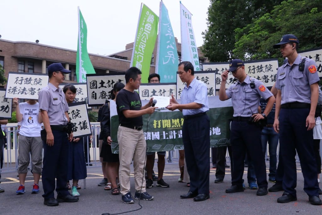 行政院交通環境資源處副處長吳政昌接受民間團體遞交全國國土計畫異議書。 圖：地球公民基金會／提供