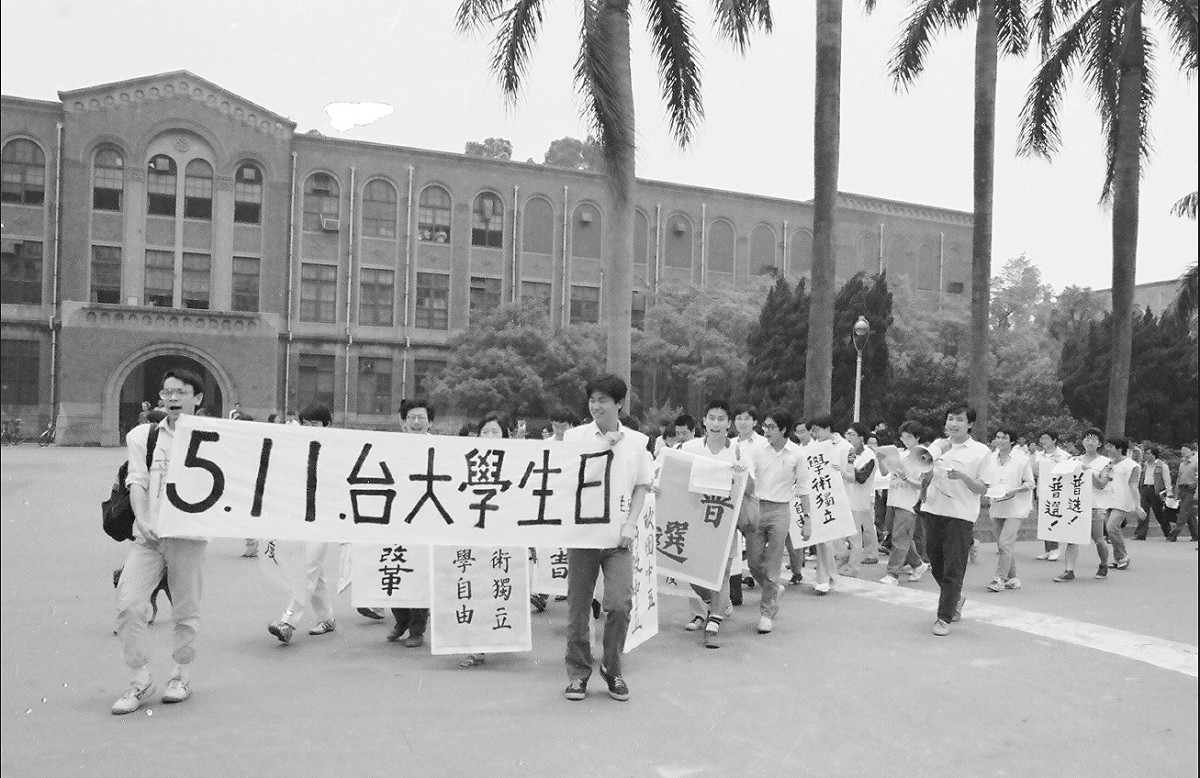數十名學生身穿噴有紅漆「普選」字樣的衣服，從台大校門口遊行到傅鐘，再回到校門口，途中學生高喊「普選」、「我愛台大」等口號，是「511台大學生日」抗爭傳統的起源。 圖：晏山農／提供