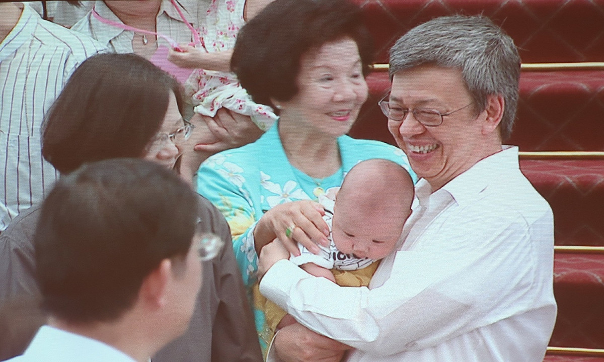 副總統陳建仁抱著一位睡著的小baby。 圖：翻拍自總統府直播畫面