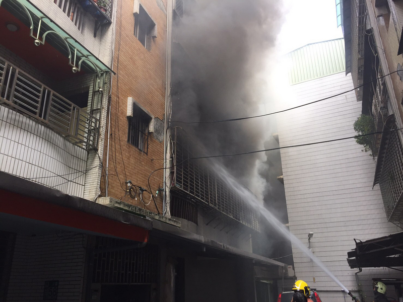 新北市八里區一處5層樓民宅4日上午發生火警，火勢從2樓向上延燒，消防局獲報立刻派遣上百名消防人員前往搶救。 圖 :新北市消防局/提供