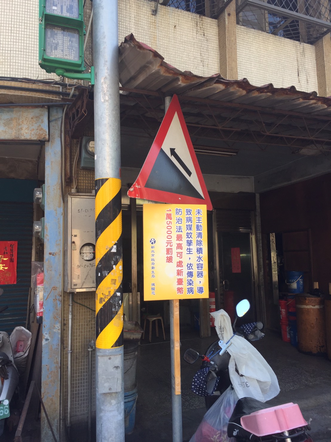 新北市府在新莊瓊林里張貼公告及樹立告示，提醒防範登革熱疫情。 圖：新北市衛生局提供