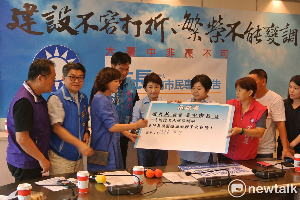 盧秀燕與國民黨市議員一一簽署承諾書，保證當選後恢復老人健保補助。 唐復年/攝