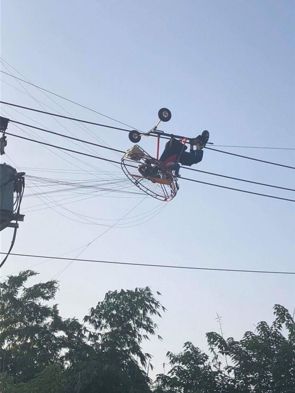 一名男子昨日玩飛行傘結果卡在高八公尺高的電線桿上。 圖：台中市消防局/提供