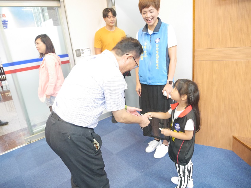 丁守中與台北市市議員參選人鍾沛君的小小助理，其女兒吳惟交換名片，展現親和力。 圖：聶良恩／攝