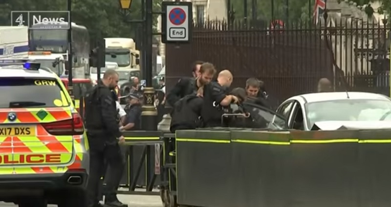 英國國會外今天發生汽車蓄意衝撞行人後撞上國會外護欄，武裝警察衝向前逮捕駕駛，持槍將他自車內拉出來。 圖：翻攝YouTube