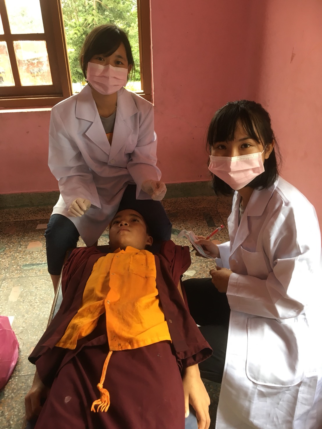 學生們為尼泊爾孩童進行診察。 圖：尼泊爾靈鷲山慈善基金會/提供