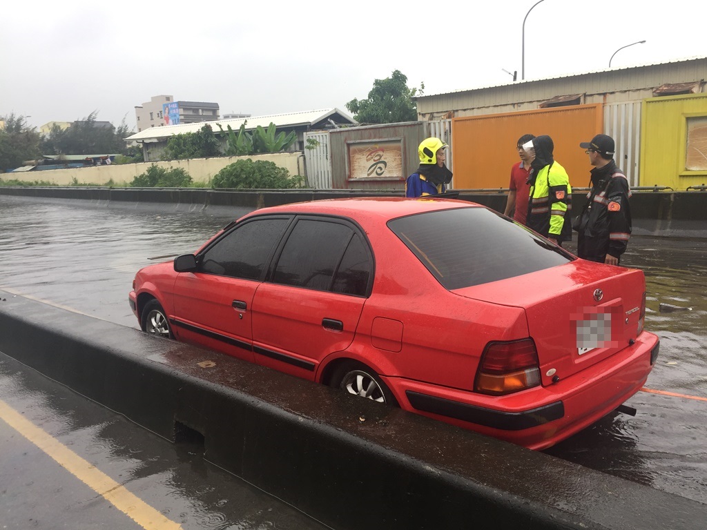 一名紅色轎車溫姓女駕駛淹水受困，消防員到場後已經脫困。 圖：翻攝自網路