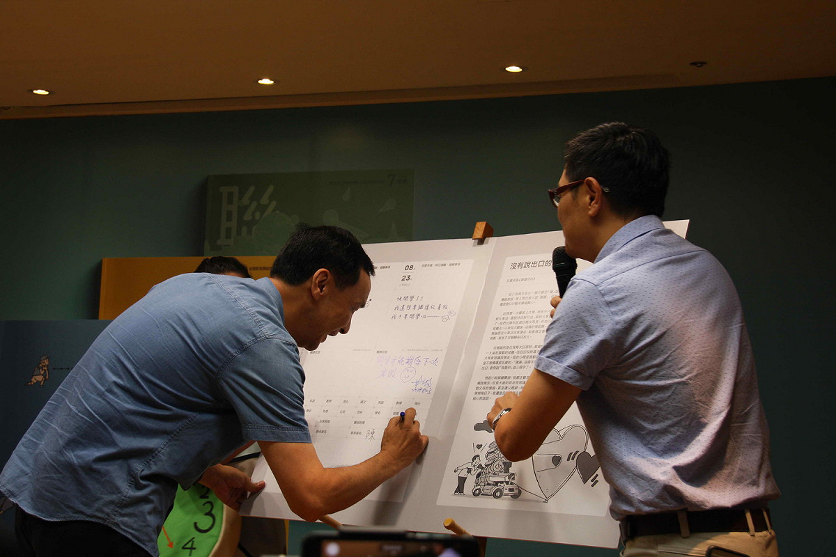 新北市府今天發表新版「國中品德教育聯絡簿」，市長朱立倫在改版聯絡簿簽名。     
 圖：王峻昌/攝
