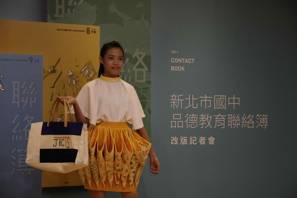 樟樹國中學生將國中品德教育聯絡簿改版設計元素，結合服裝設計，在發表會走秀。   
 圖：王峻昌/攝