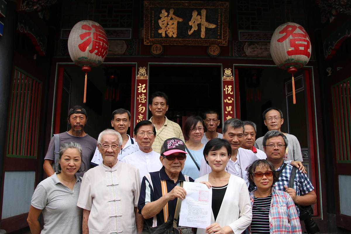文化部長鄭麗君至陳悅記祖宅親送國定古蹟公告，前排左二為布袋戲國寶大師陳錫煌。 圖：文化部提供
