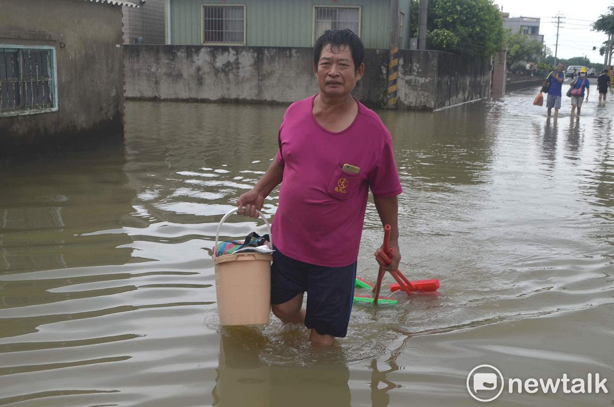 823大水災第四天，嘉義縣義竹鄉後鎮村還泡在水中，居民手持打掃用具，準備清理家園。 圖：蔡坤龍/攝（資料照片）