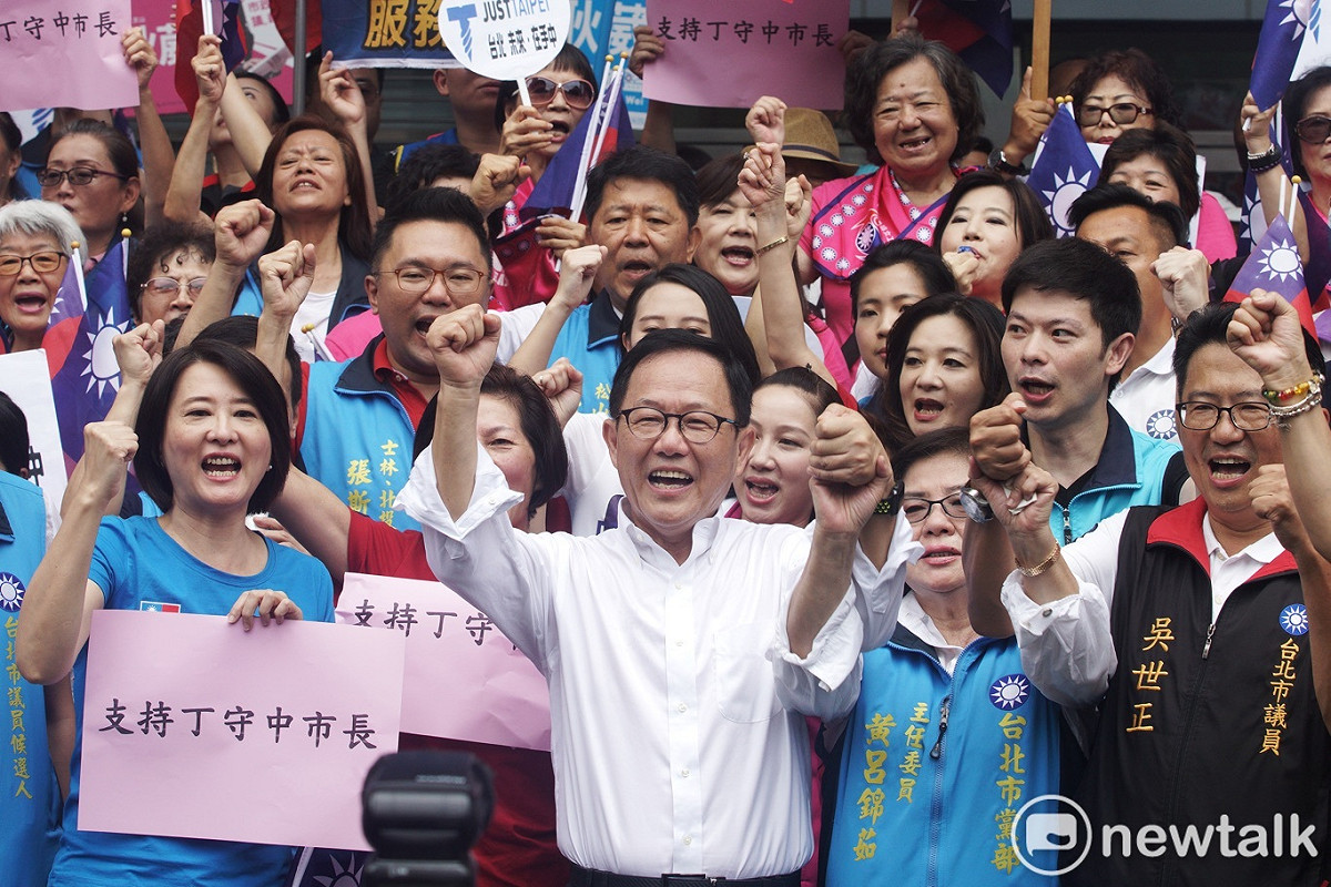 國民黨市長參選人丁守中和多位市議員參選人在市選委會外呼口號，場面熱鬧滾滾。 圖：張良一/攝