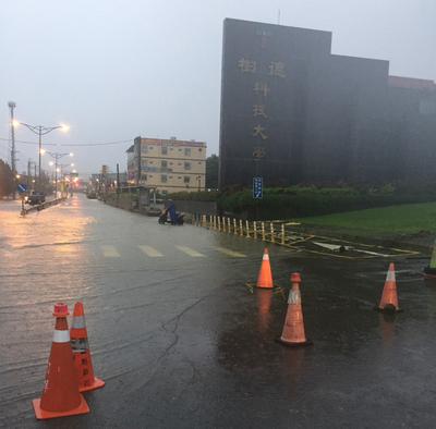 高雄市28日清晨持續強降雨，部分地區時雨量破80毫米 ，很多地區積水。圖為位在燕巢區樹德科技大學前道路積水封閉。 圖：中央社（民眾提供）