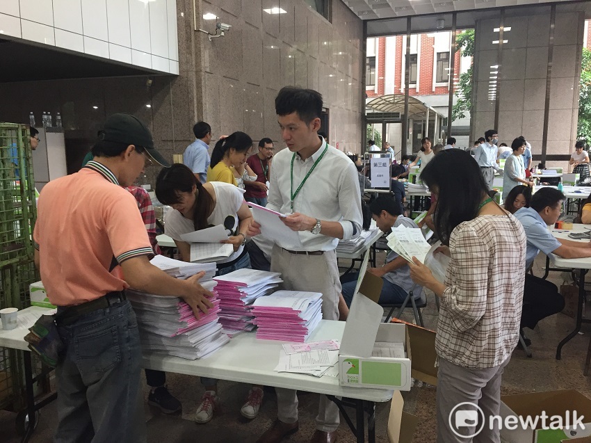 中選會一樓大廳堆積了大量的公投連署書，工作人員正努力點收。 圖：趙婉淳／攝
