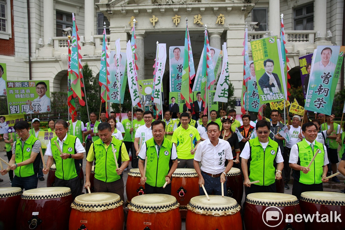 「龍系」台中市議員參選人以揮旗、擊鼓的方式，象徵「一鼓作氣、旗開得勝」。 圖：唐復年/攝