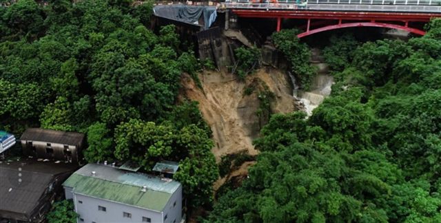 萬壽山橋路面大崩塌，泥流持續沖刷，山腳下民眾岌岌可危。 圖：岡山分局／提供