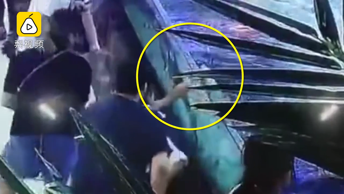 女童站在玻璃護欄旁邊觀賞，突然被跳出的鯊魚咬傷，導致右手多處骨折。 圖：梨視頻影片截圖