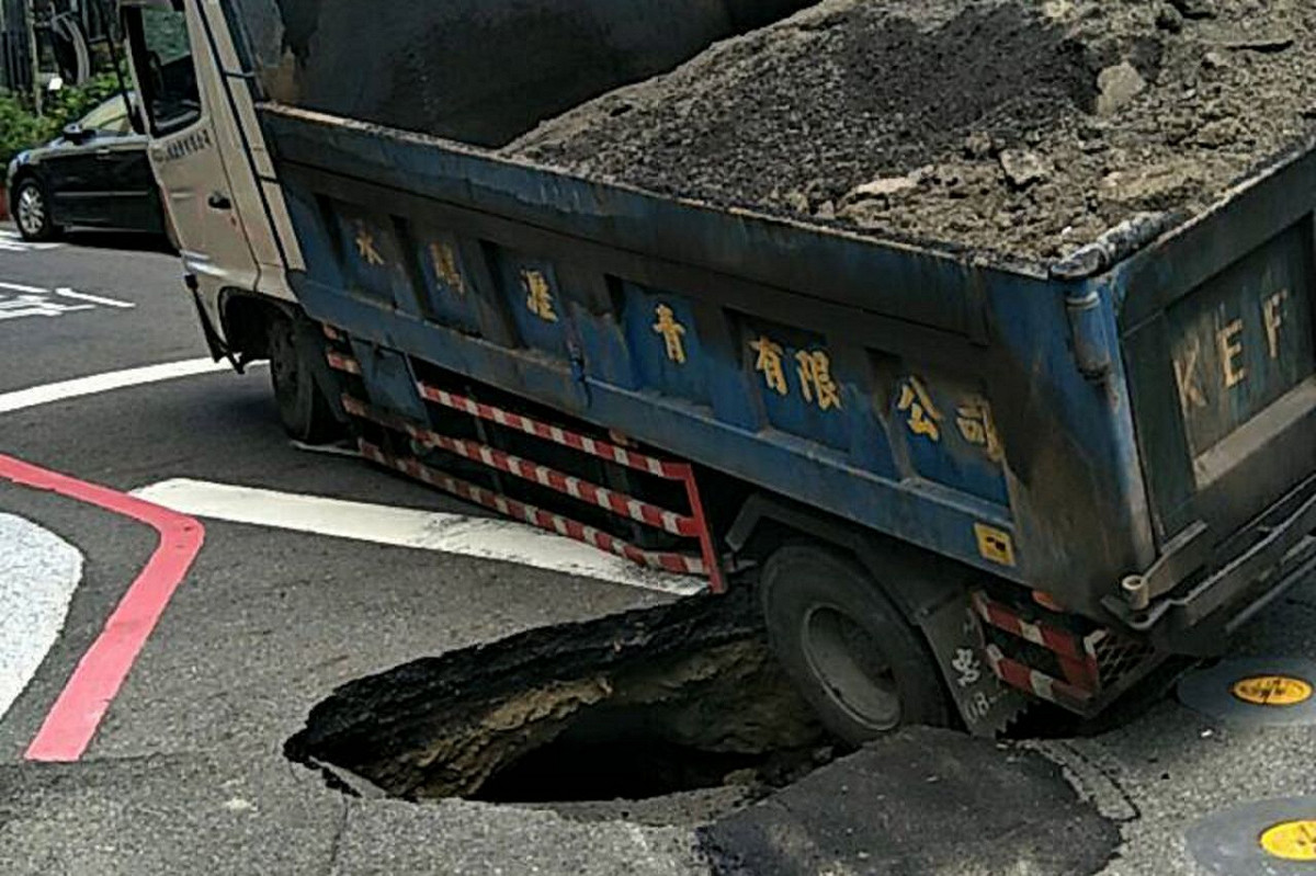 台南道路坍塌導致一輛卡車後輪掉進洞內，動彈不得。 圖：翻攝我是台南人臉書