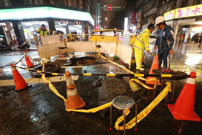 台北市8日降下大雨，造成西門町人孔蓋暴衝，水柱一 度衝到數層樓高，事發現場隨即被警方拉起封鎖線，台 北市衛生下水道工程處人員晚間也趕抵現場處理善後。 圖：中央社
