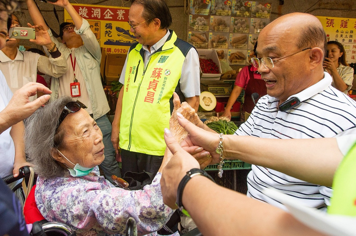 高齡100歲的阿嬤見到蘇貞昌，開心地比大拇指，誇讚蘇貞昌「我知道你有做事！」 圖：蘇貞昌競選辦公室／提供