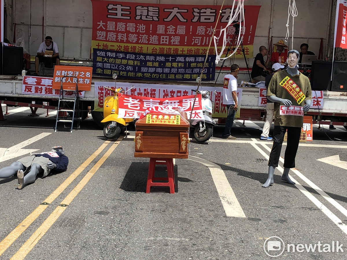 除了上百輛大貨車、大卡車停在中山南路與忠孝西路口外，旁邊還停了一口棺材和兩個假人偶。 圖：謝莉慧/攝