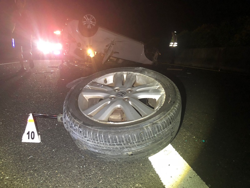 一輛白色轎車14日深夜行經國道一號苗栗北上130.5公里路段突然翻覆，車內2人被拋出車外當場慘死，警方勘查現場跡證，懷疑與車輛右後輪爆胎有關，將進一步調查釐清事故原因。 圖/中央社