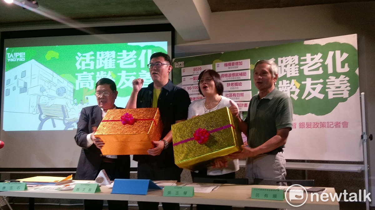 姚文智在記者會上和與會者共同送出銀髮政策禮盒。 圖:陳佩君/攝