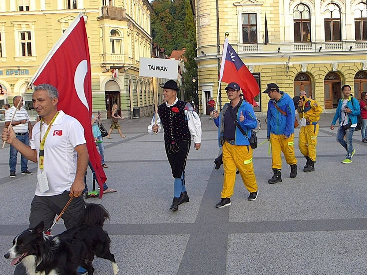腿腿及搜救犬隊同仁3員在18日上午平安抵達世界救難犬錦標賽區，並完成報到手續。我國國旗在異鄉飄揚。 圖：翻攝自蕭煥章臉書