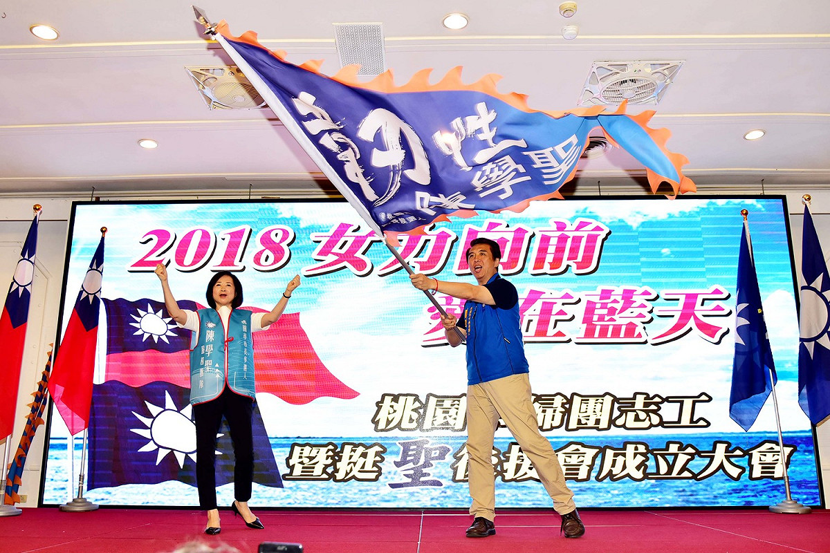 國民黨主席吳敦義夫人蔡令怡以正統「國民黨藍天志工團總團長」身份，授予陳學聖「韌性」戰旗，意味與楊麗環劃清界線。 圖：陳學聖競選辦公室／提供