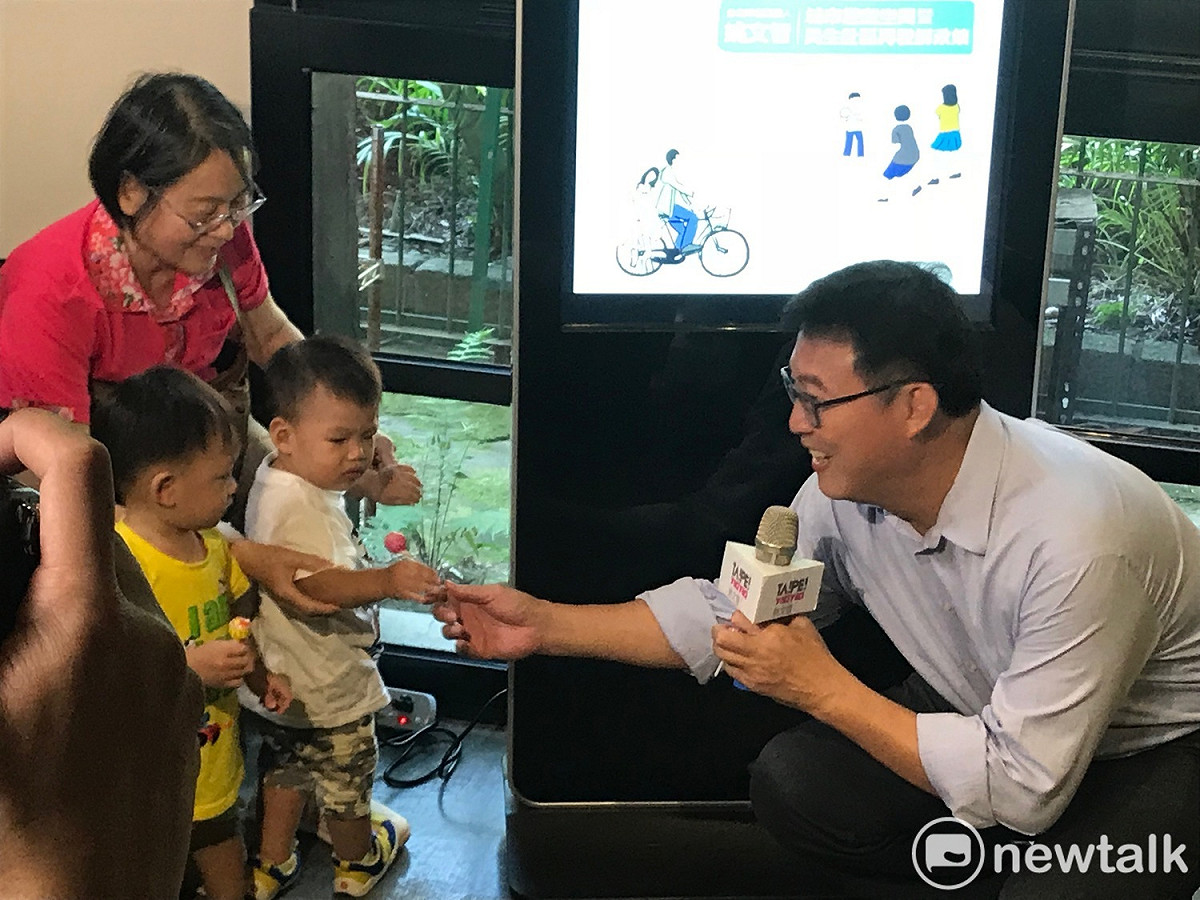 姚文智拿糖果贈送給現場孩童。 圖 : 周煊惠 / 攝