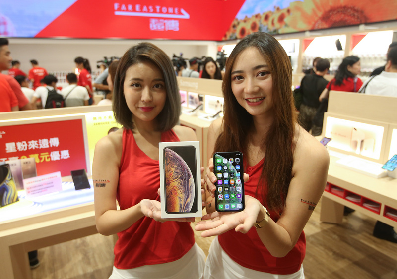 蘋果iPhone XS系列21日在台開賣，遠傳電信開賣當天於「信義威秀門市」提供加碼禮，首名申辦iPhone XS系列的消費者，將額外獲得遠傳準備的紅色iPhone XR64GB手機，而當天威秀門市排隊前50名消費者還可獲贈價值超過新台幣3000元的福袋。 圖 : 中央社