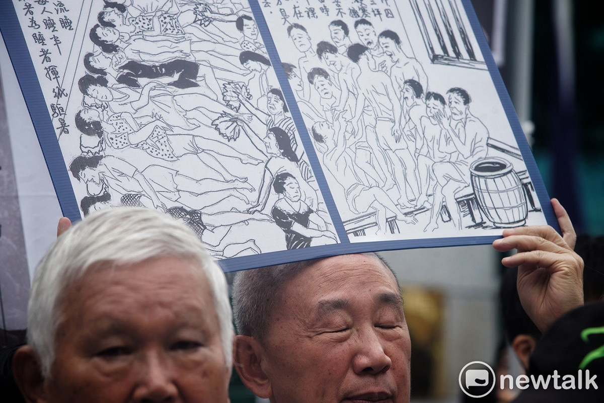 一位政治受難者代表高舉白色恐怖時代被國民黨關在大牢的非人道情況的畫像。 圖：張良一/攝