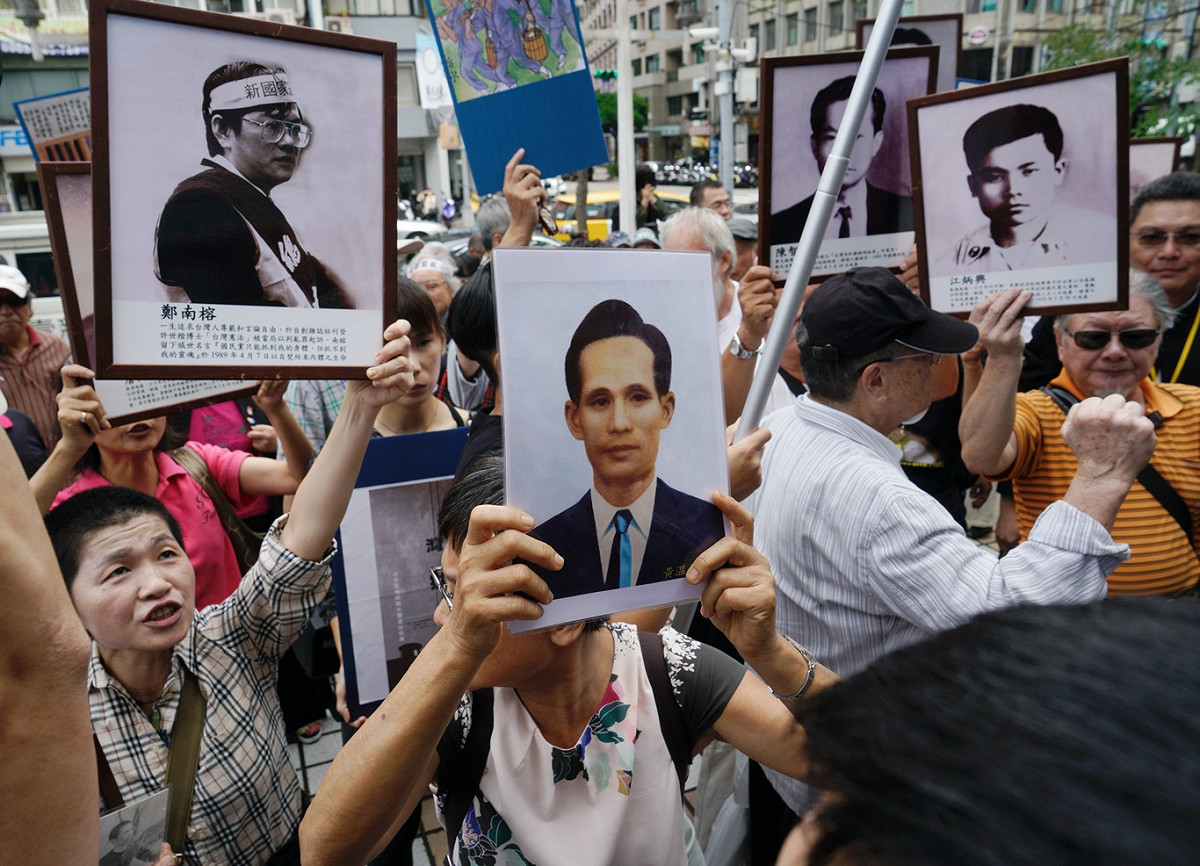 政治受難者團體高舉政治受難者遺像，並將「東廠」名號物歸原主，奉還國民黨，而與警方爆發推擠衝突。 圖：張良一/攝