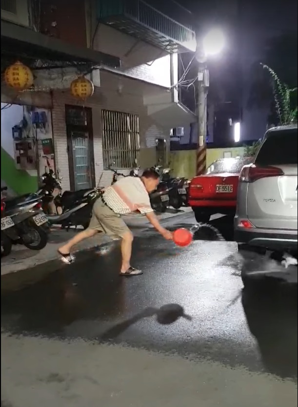 疑似虐貓的中年男子將熱水往車底下的流浪貓潑去。 圖：翻攝自臉書社團《貓咪也瘋狂俱樂部 CrazyCat club》