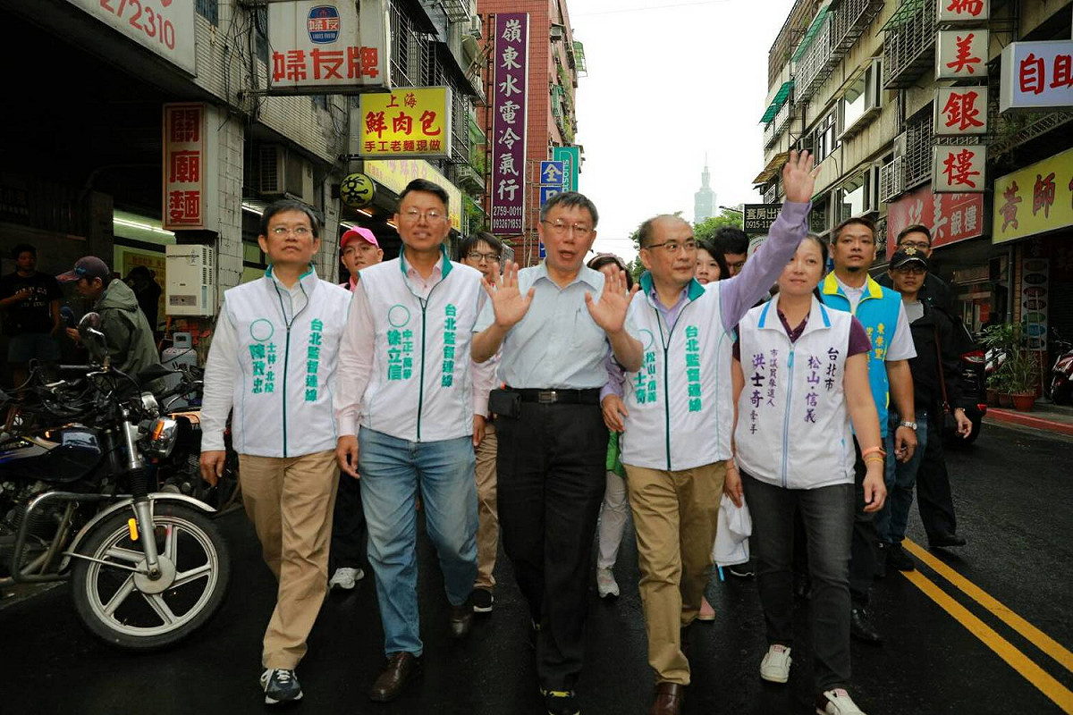 柯文哲與洪士奇前往上香途中，不斷與民眾打招呼。 圖：洪士奇競選辦公室/提供