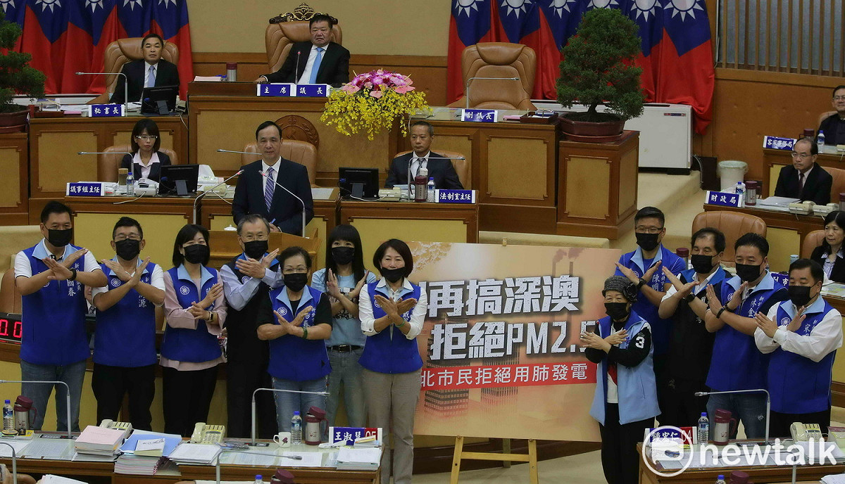 新北市議會國民黨團總質詢，議員們戴上口罩反對深澳燃煤電廠，作球給朱立倫說明理念。 圖：王峻昌/攝