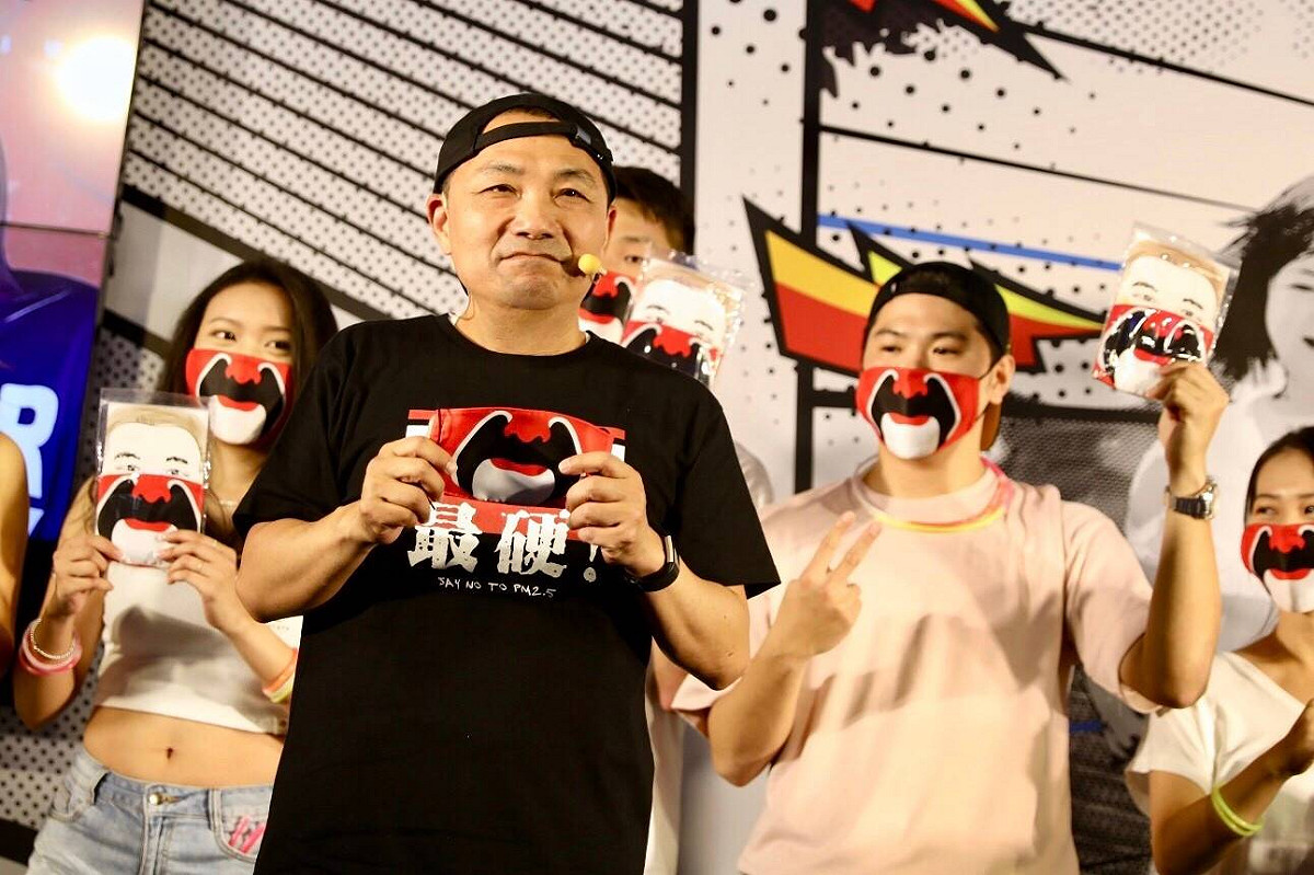 侯友宜秀出以關公臉譜設計的「侯大霾罩」表示，明天的電音趴活動將免費送出千份他親自拿去關公廟過火求平安的「關罩」送給大家。 圖：侯友宜競選辦公室／提供