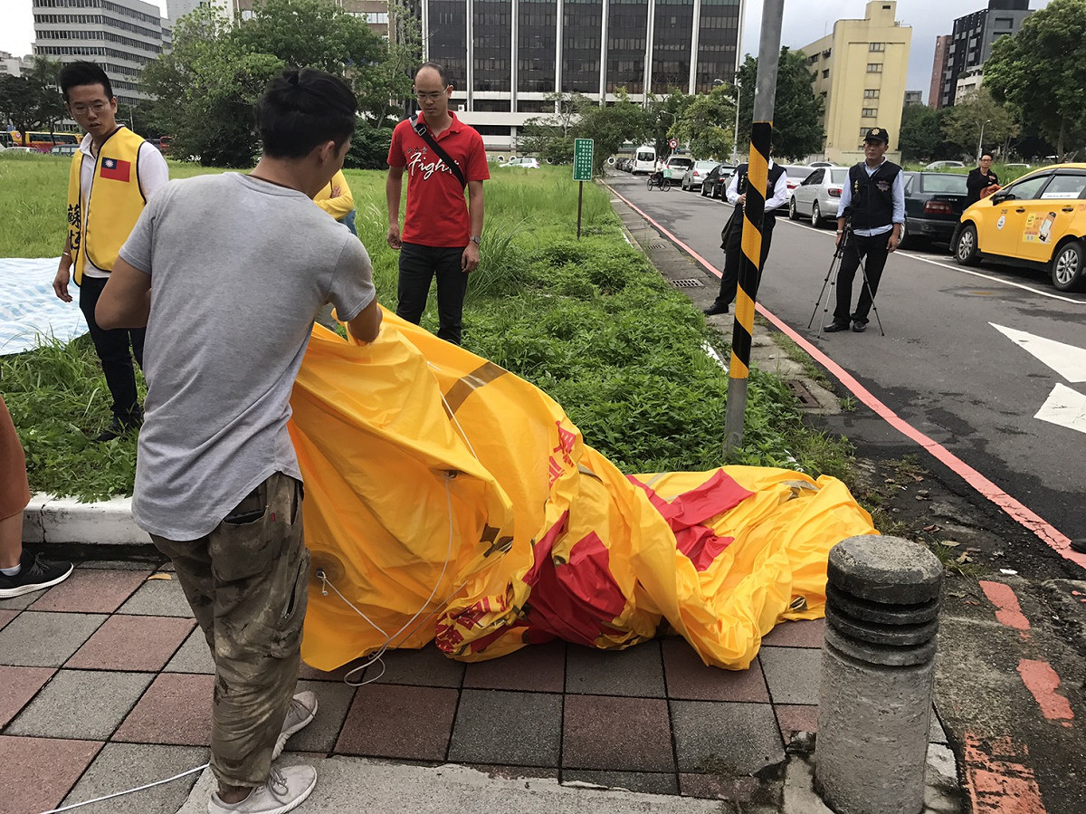 大安分局發現約20名群眾欲施放高空氣球時，即予以柔性勸導，並說明相關規定及維安要求，經多次勸導無效，於9時28分第一次舉牌警告，9時31分民眾主動將氣球洩氣，施放氣球事件方才平和圓滿結束。 圖：台北市警察局/提供