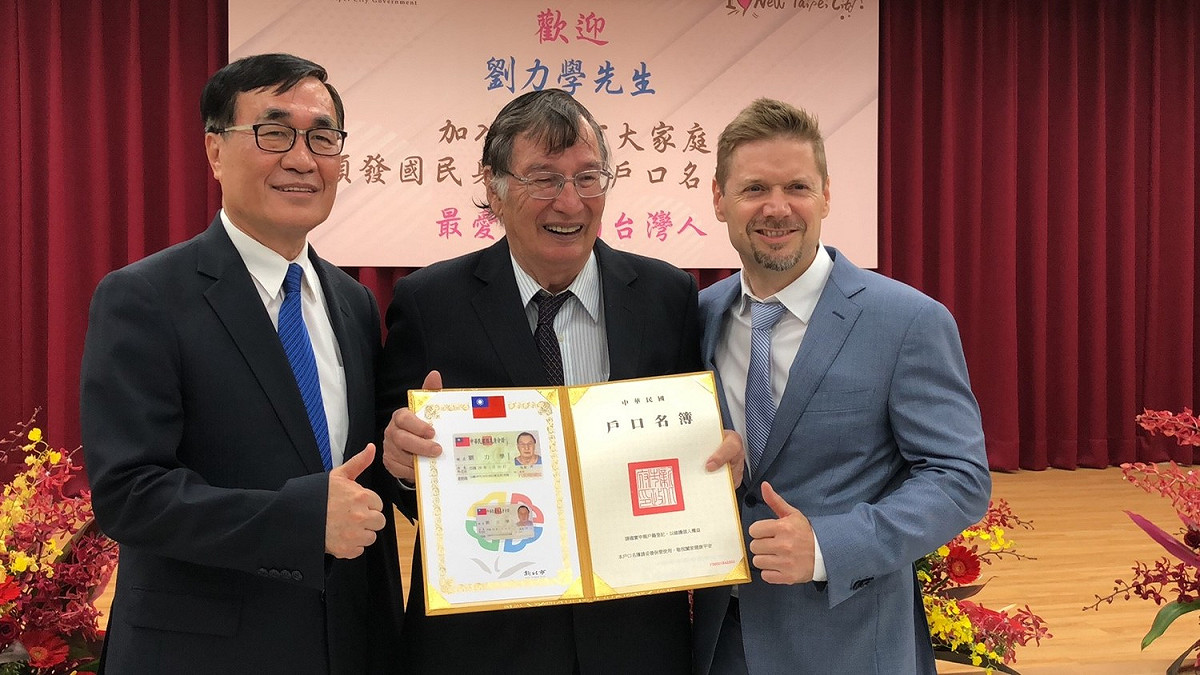 78歲的劉力學（中）以「殊勳」之榮，在加拿大駐台北貿易辦事處代表芮喬丹見證下（右），由副市長李四川頒發我國身分證、戶口名簿。
       圖：新北市民政局/提供