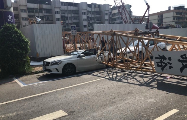 高雄市三民區一輛賓士車被倒塌的吊車吊臂壓毀。 圖：翻攝爆料公社