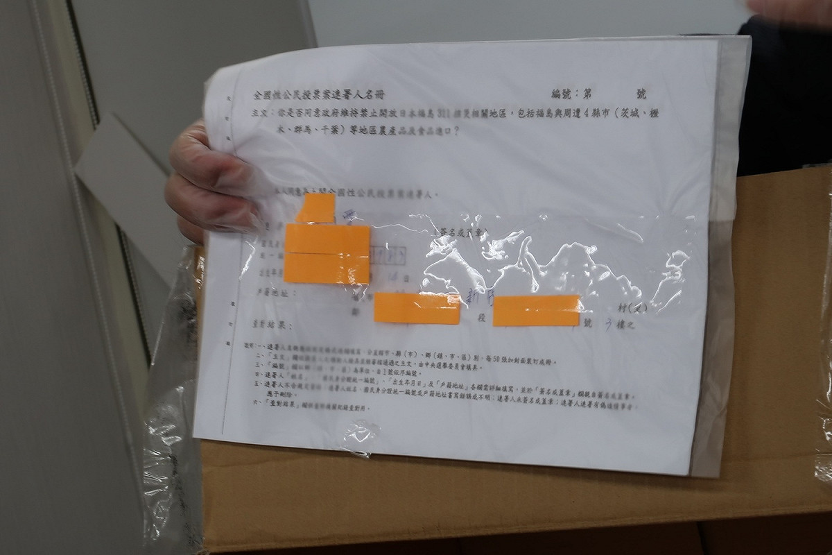 律師裘佩恩15日出示掌握的邱姓員工福島核食連署書。 圖：林朝億/攝
