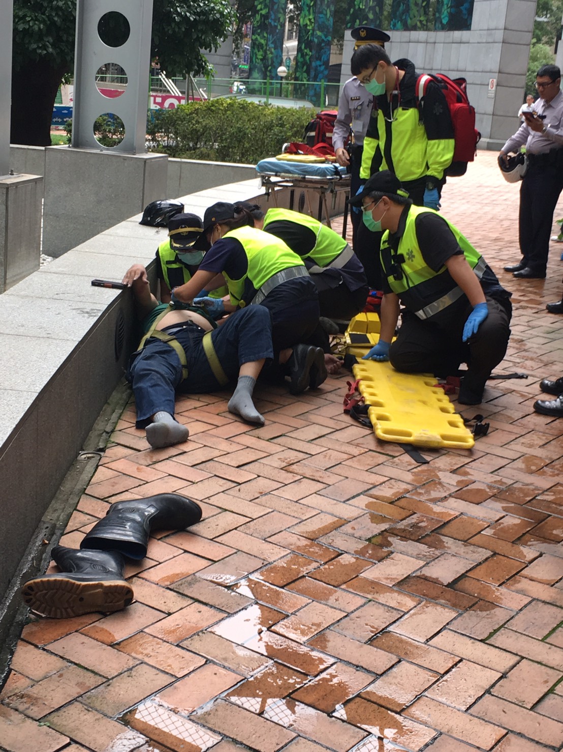 陳姓洗窗工人今早在新北市府工作時跌落地面，頭部血流，被緊急送醫。       
 圖：讀者提供