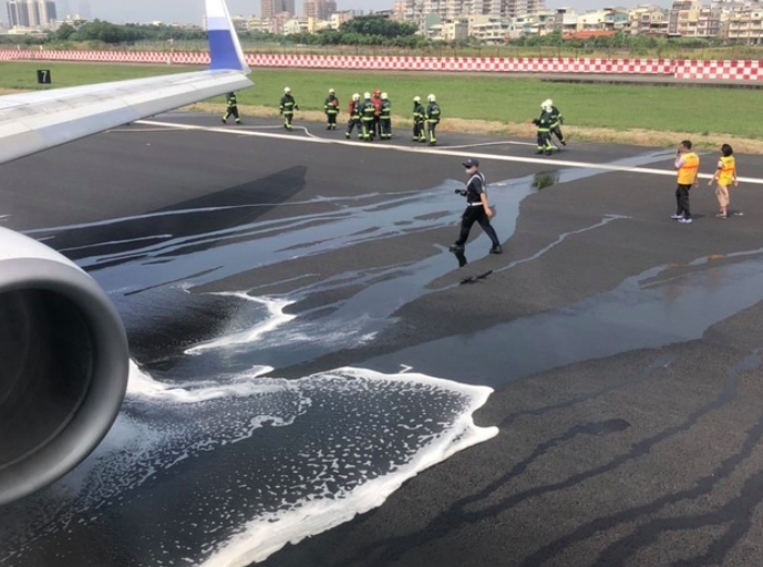 華航機降落爆胎，小港機場消防馳援，朝機翼下方猛烈灌救降溫。 圖：翻攝我是高雄人臉書專頁