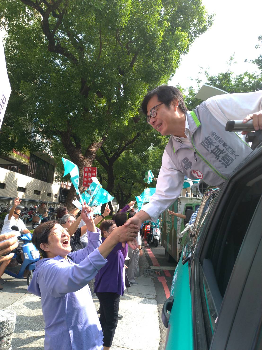 陳其邁拜票車輛展開掃街，沿街還有不少在地民眾搖著旗幟，沿街高呼凍蒜。 圖/陳其邁選辦