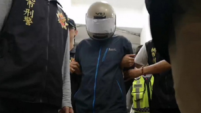 桃園市梁姓男子（中）18日晚間逆倫弒母，19日被依殺直系血親尊親屬罪嫌移送桃檢偵辦；梁男下午頭戴安全帽離開警局時，沿途低頭不語。 圖：桃園中壢警方/提供