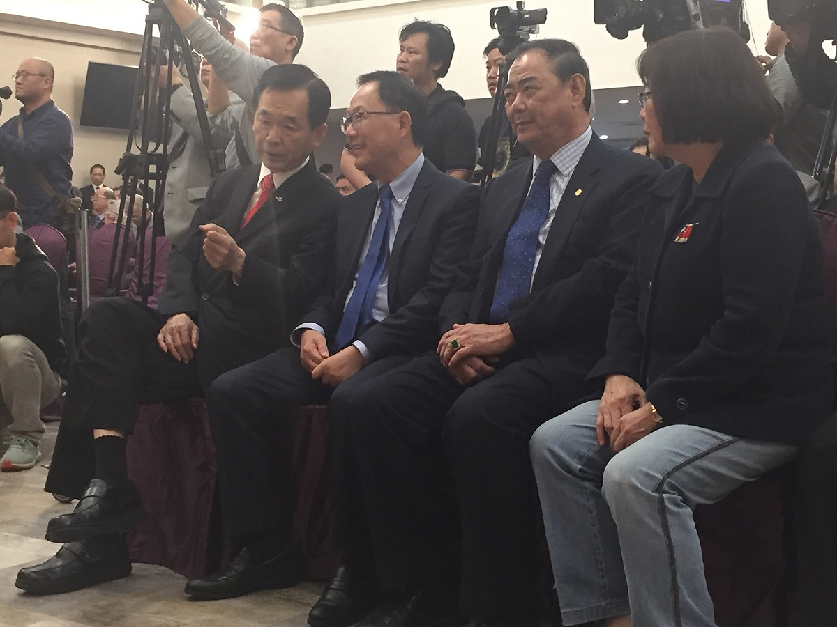 丁守中（右三）與王應傑（右四）下台坐在位置上，王則頻頻與丁交頭接耳，彷彿藉機給予建議。 圖：趙婉淳／攝